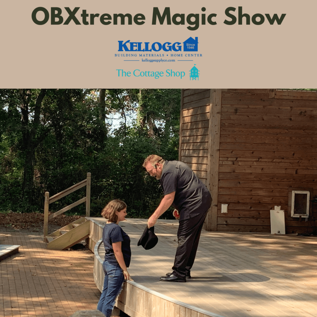 Obxtreme magic show with Kellogg and Cottage Shop logos. Magician is showing a hat to a child